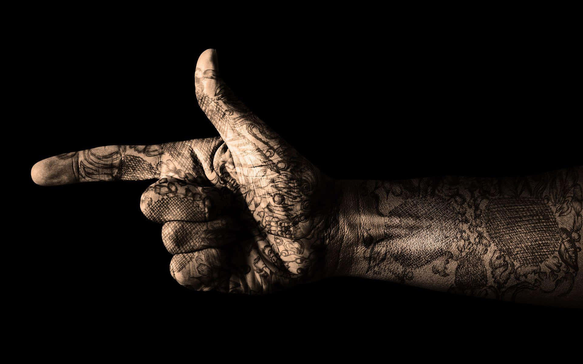 A Hand With Tattoos Pointing At Something