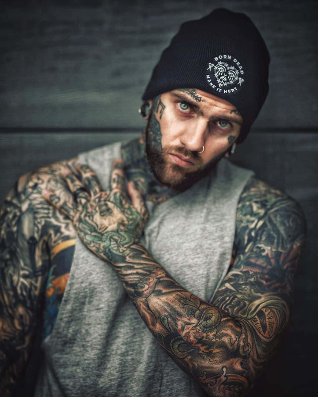 A Man With Tattoos On His Arms And A Beanie