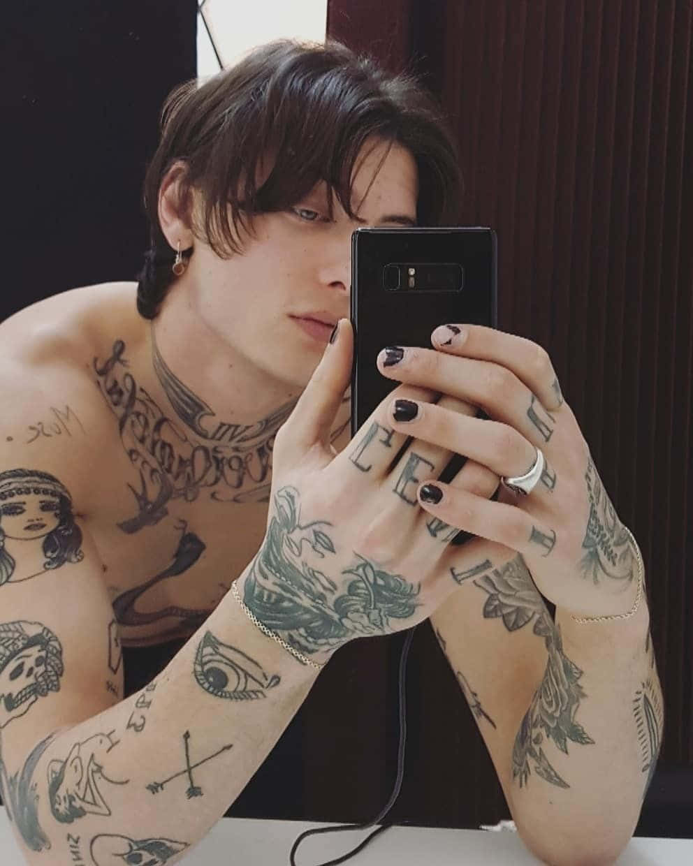 A Man With Tattoos Taking A Selfie