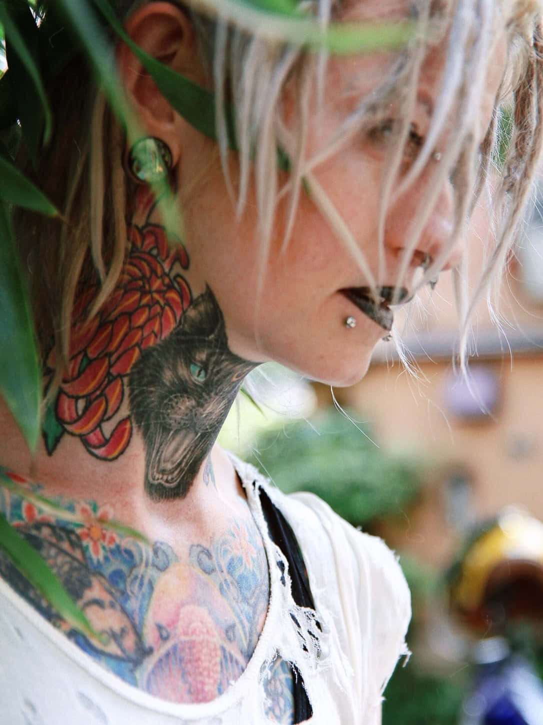 A beautiful tattooed woman looking pensively into the distance.