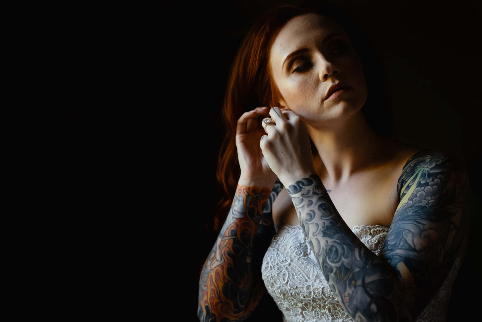 Unamujer Con Tatuajes En Los Brazos Está Posando Para Una Foto.
