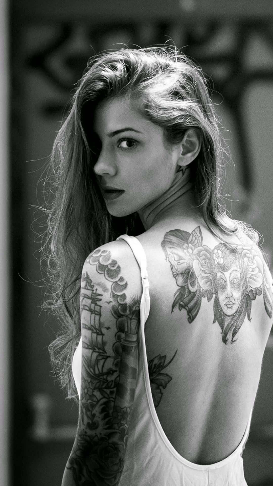A Woman With Tattoos On Her Back