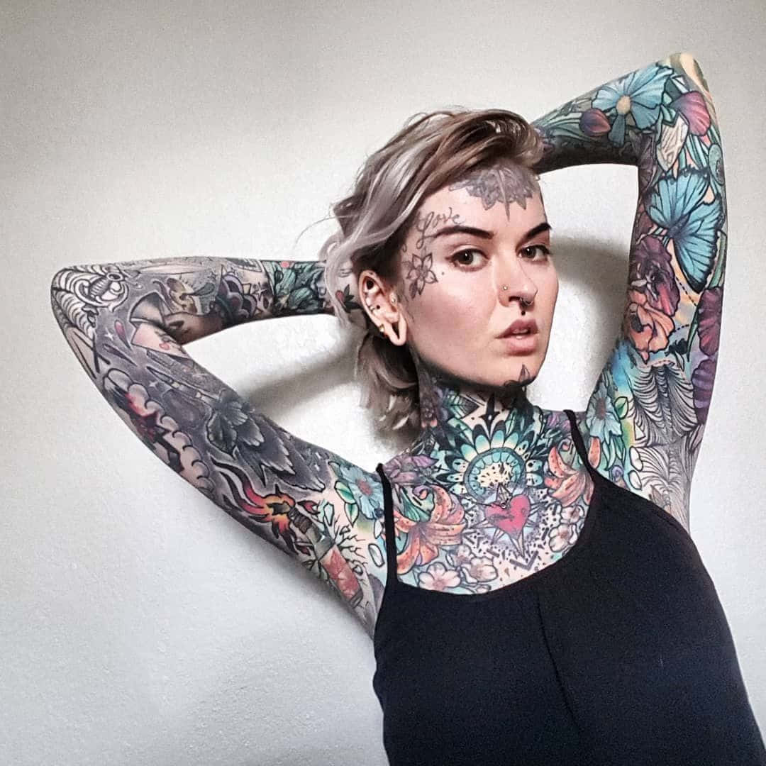 A Woman With Tattoos On Her Arms And Shoulders