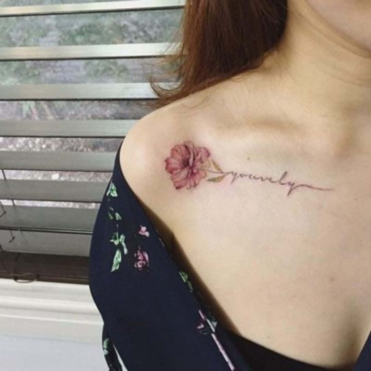 A Woman With A Flower Tattoo On Her Shoulder