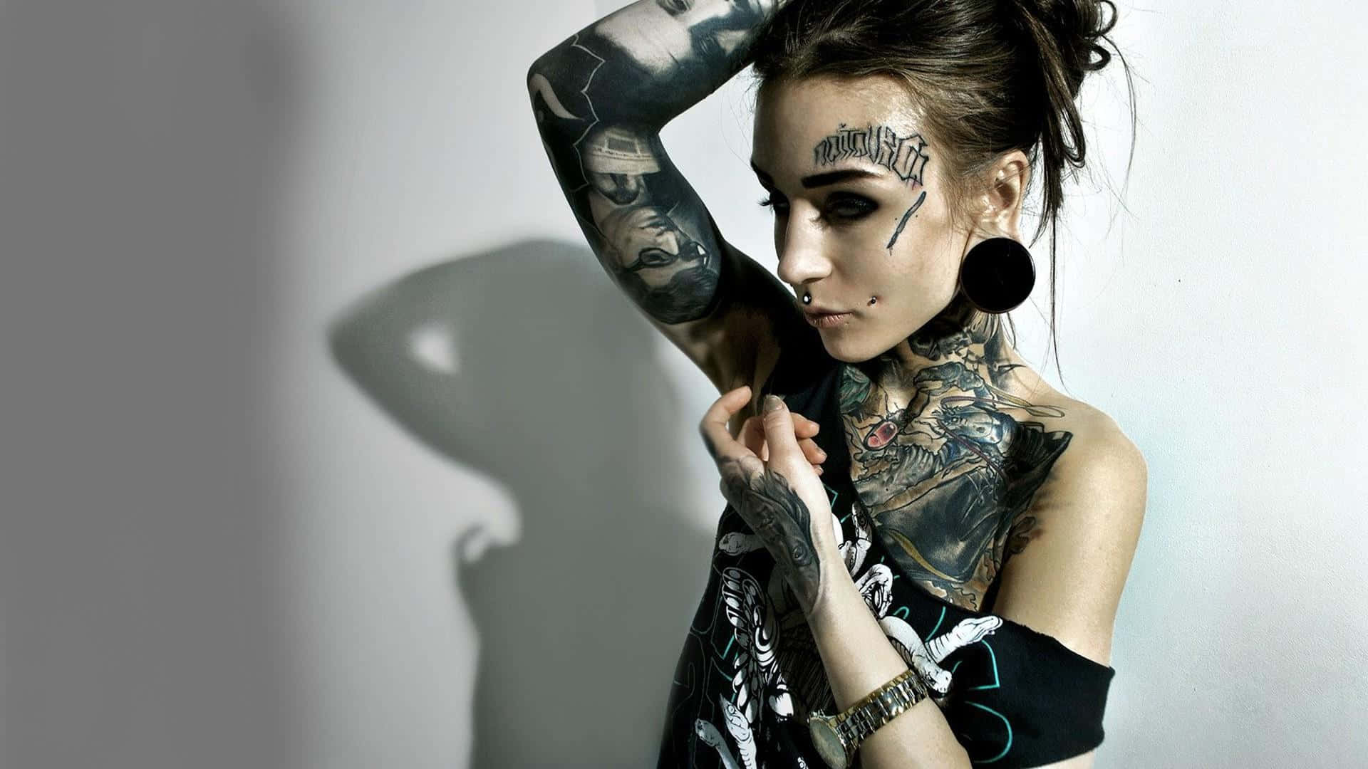 A Woman With Tattoos On Her Arm Posing