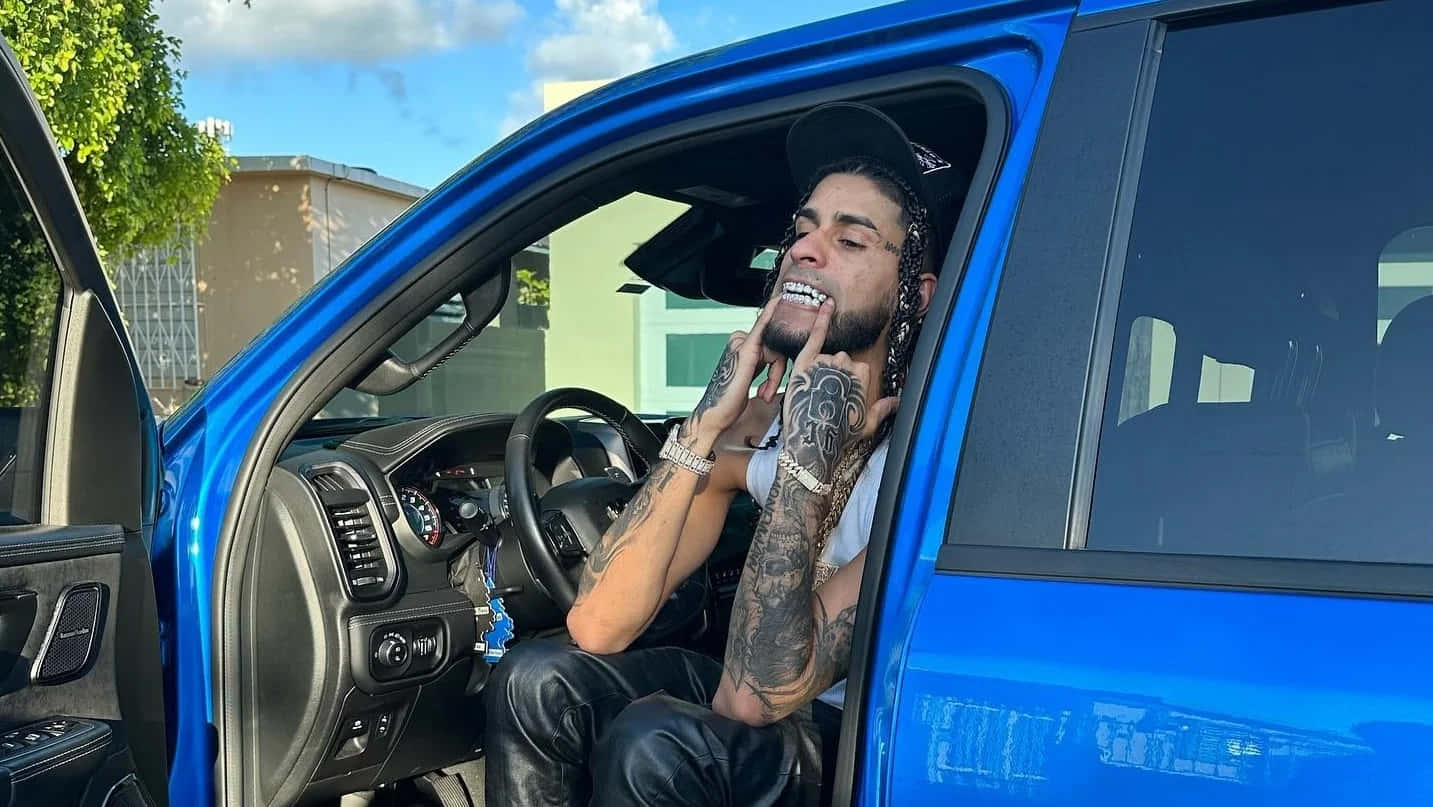 Tattooed Man Smilingin Blue Truck Wallpaper