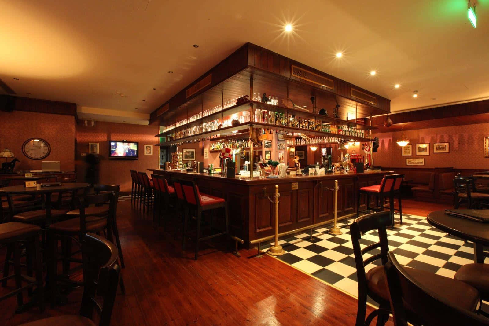 A Bar With A Checkered Floor And Wooden Tables