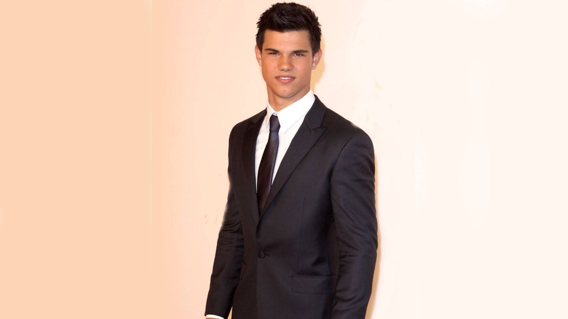 Taylor Lautner i en sort dragt Tapet Wallpaper