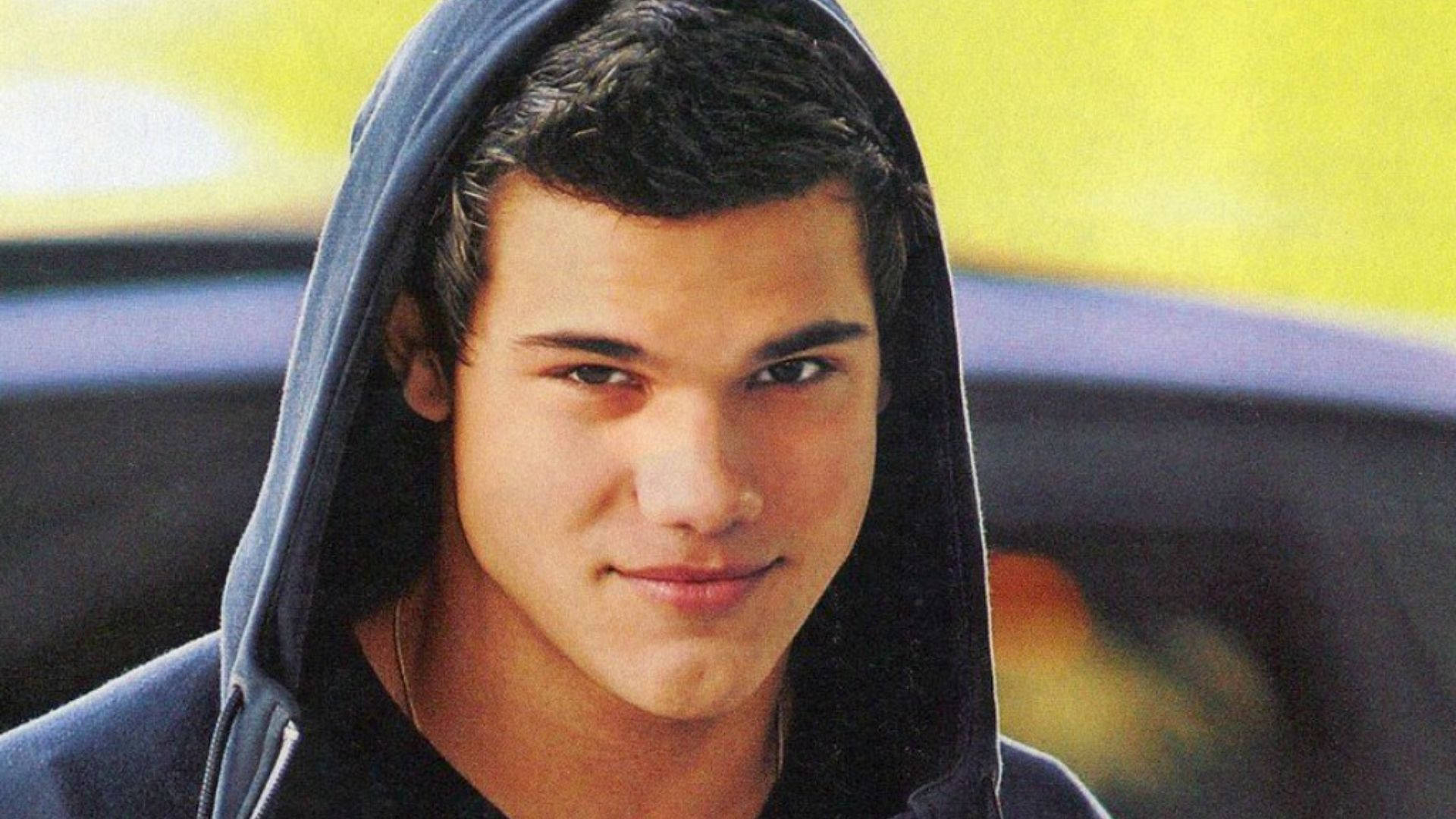 Taylor Lautner smiler sødt på en solrig dag Wallpaper