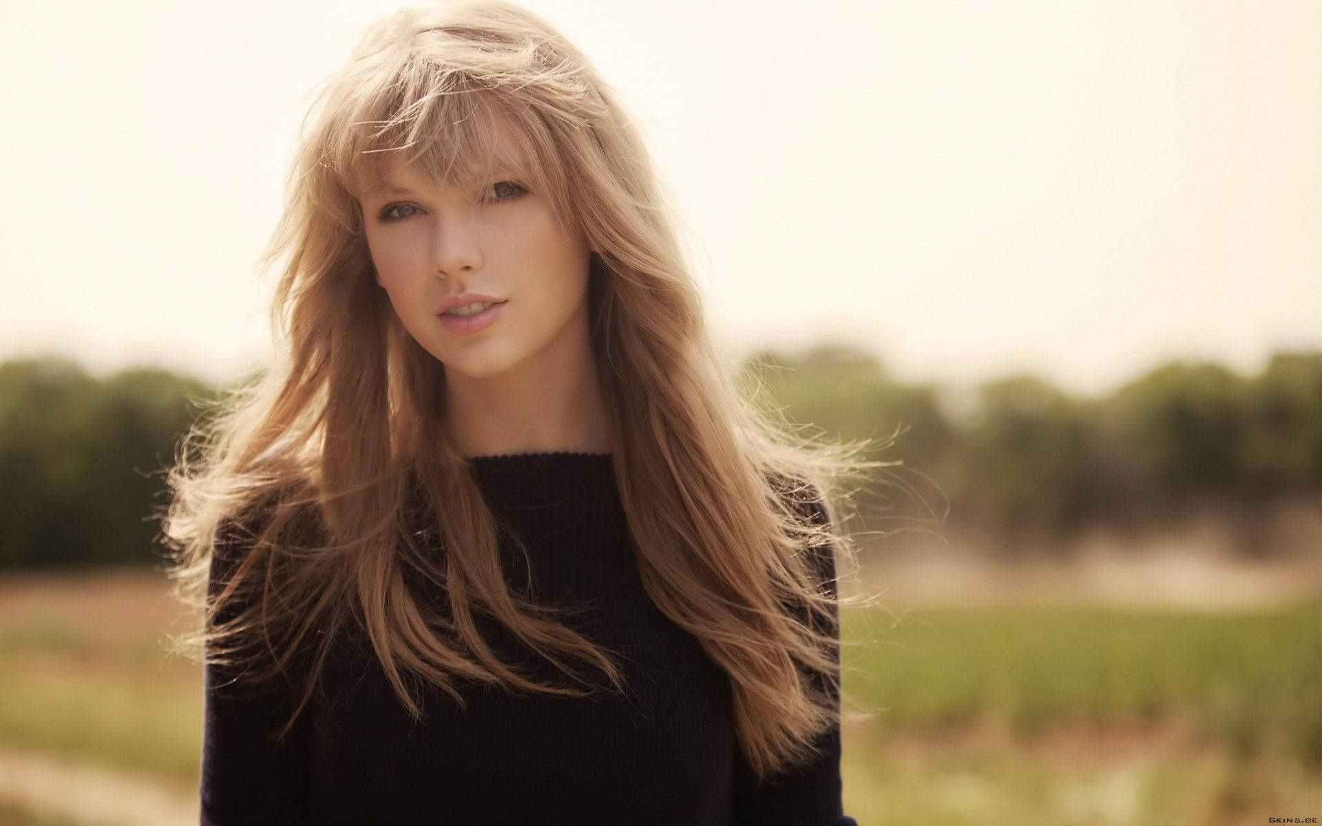 Taylor Swift music video with straightened hair and black shirt.