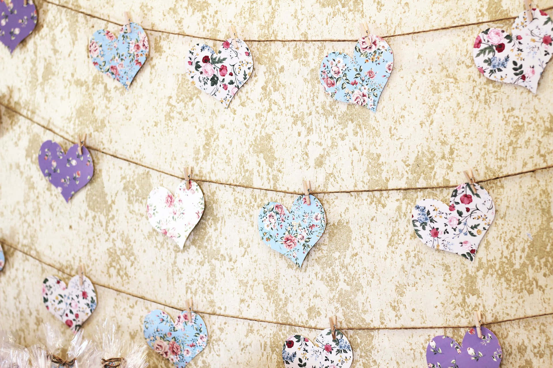 A Garland Of Paper Hearts Hanging From Clothespins