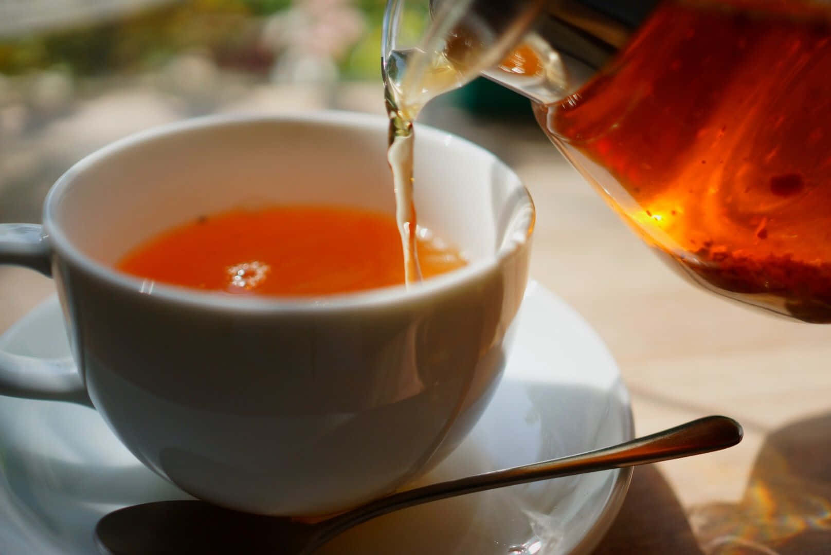 A Cup Of Tea Is Being Poured Into A Cup