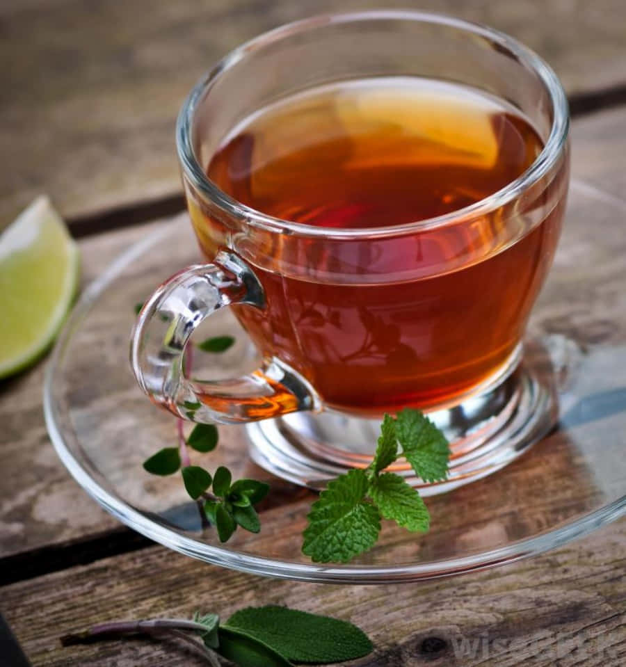 A Cup Of Tea With Mint Leaves And A Slice Of Lime