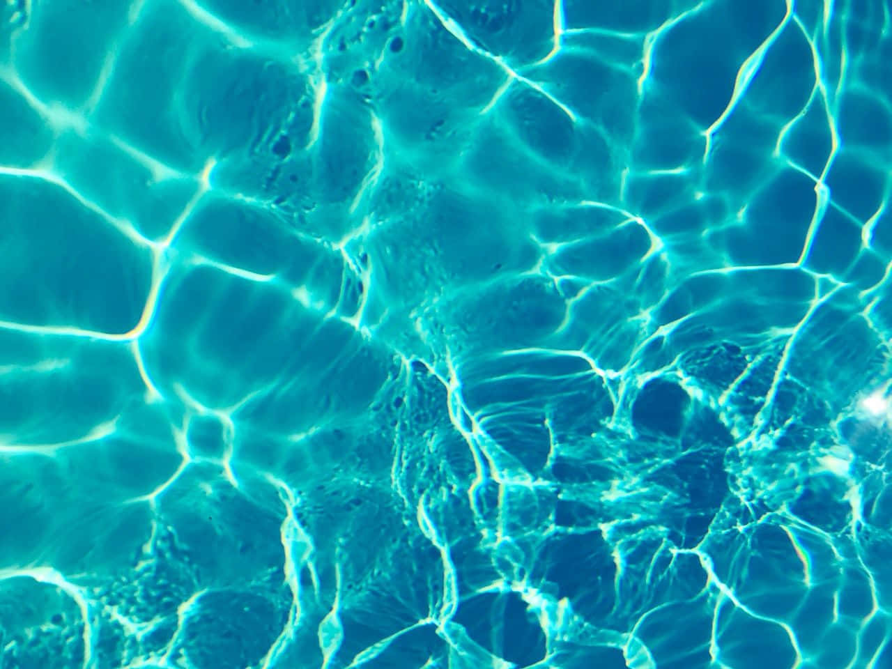 A Close Up Of A Blue Pool With Clear Water Wallpaper