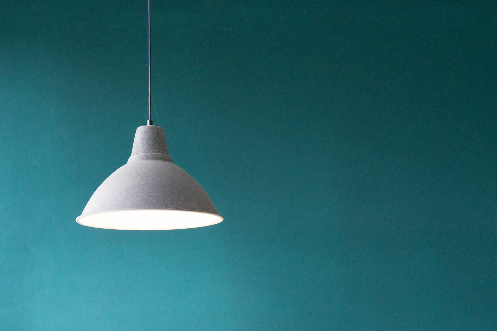 "The Charm of Simplicity: Teal Wall with Hanging Lamp" Wallpaper