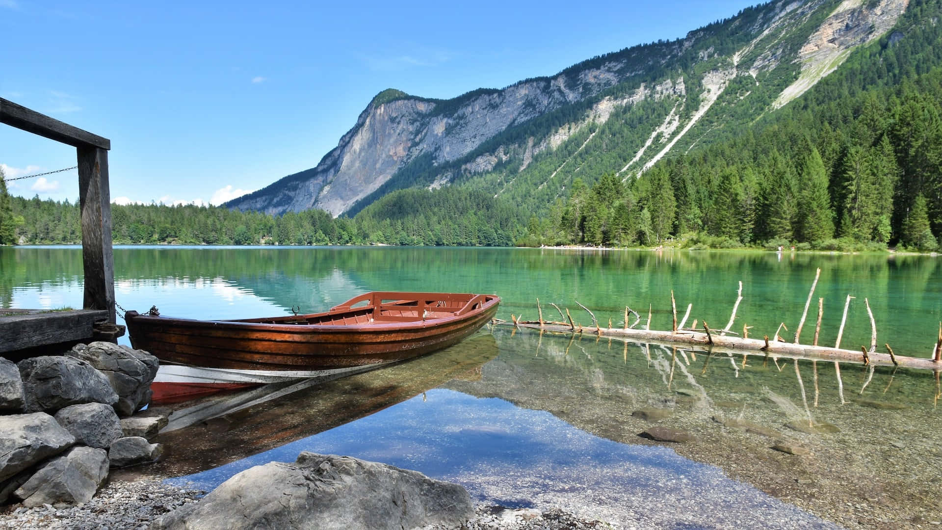 A Boat Docked In A Lake Near Mountains