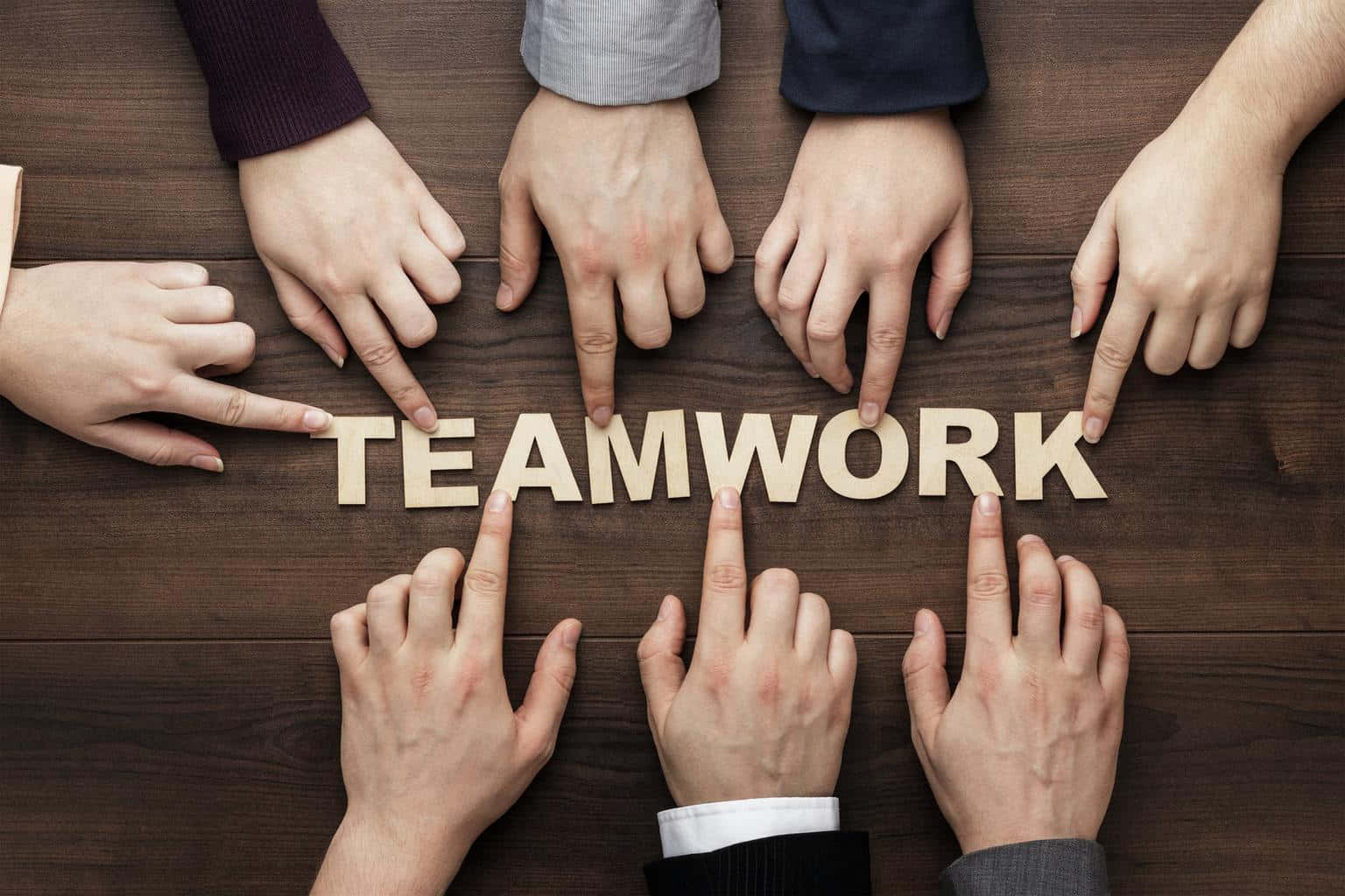 Teamwork - Business People's Hands Forming The Word Wallpaper