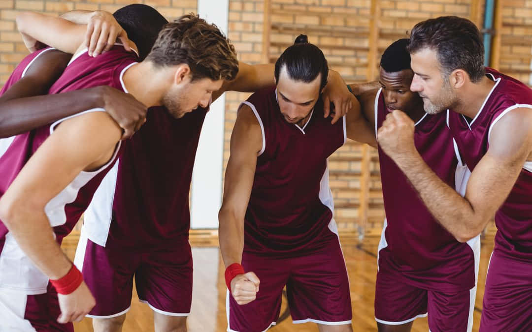 A Group Of Basketball Players Huddle Together