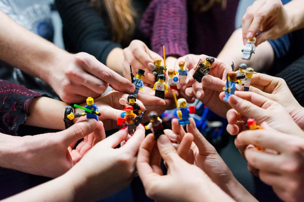 A Group Of People Holding Lego Figures Wallpaper