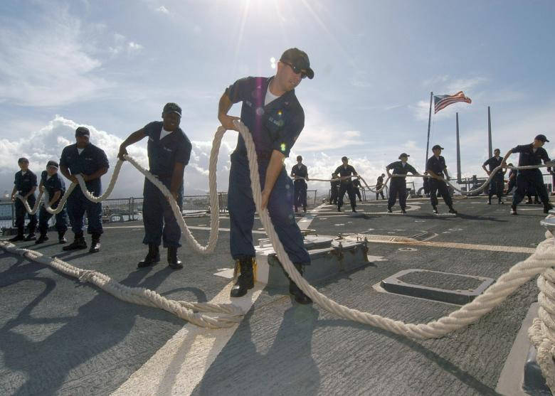 Teamarbejdende sømænd der trækker i et naivt blåt hav Wallpaper