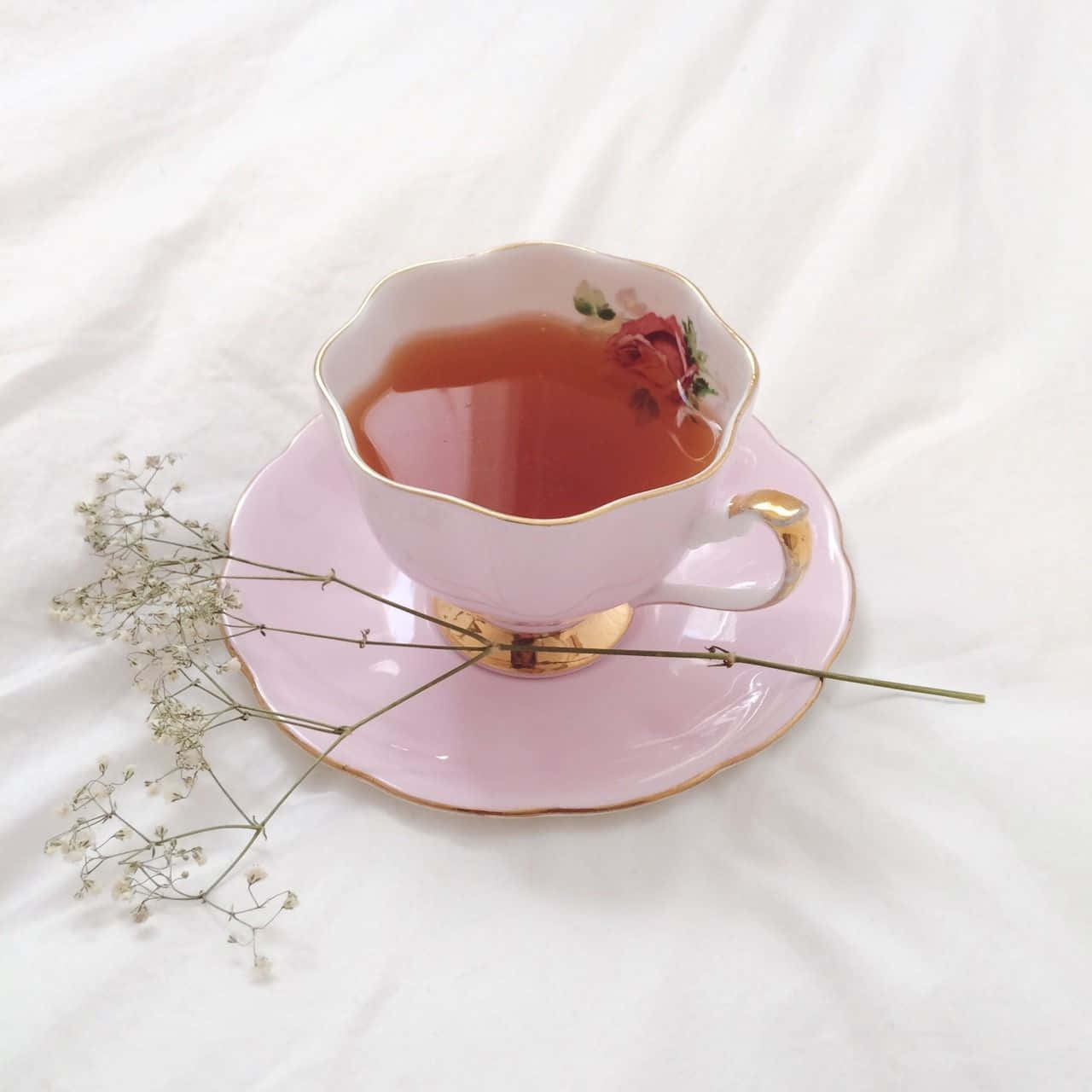 A Pink Tea Cup With Flowers On It