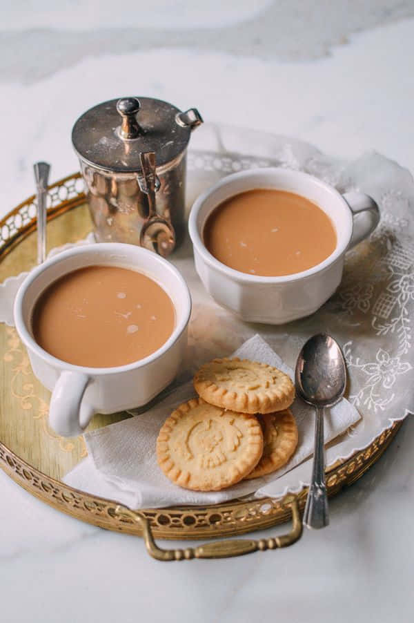Two Cups Of Tea And Cookies On A Tray