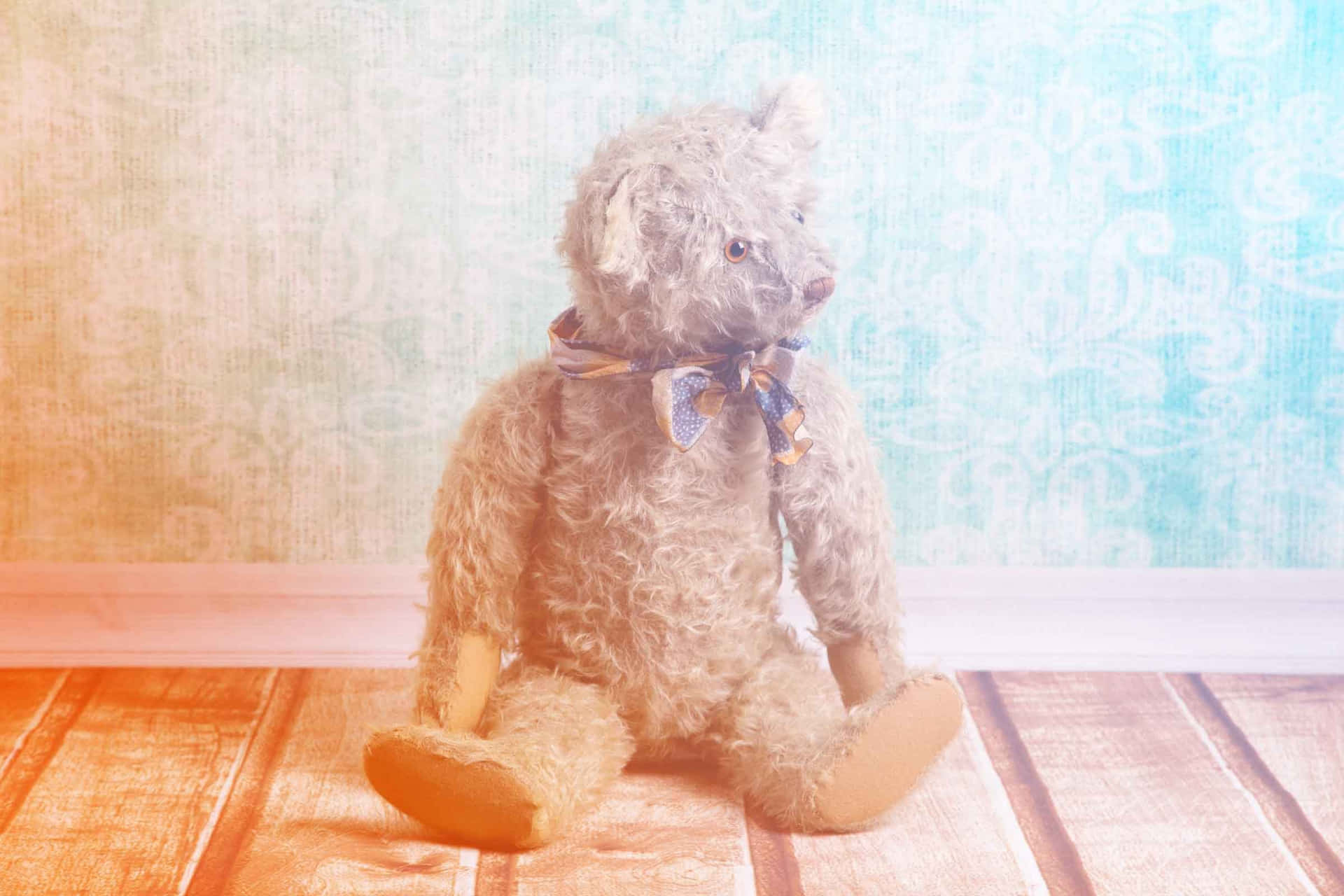 A Teddy Bear Sitting On A Wooden Floor