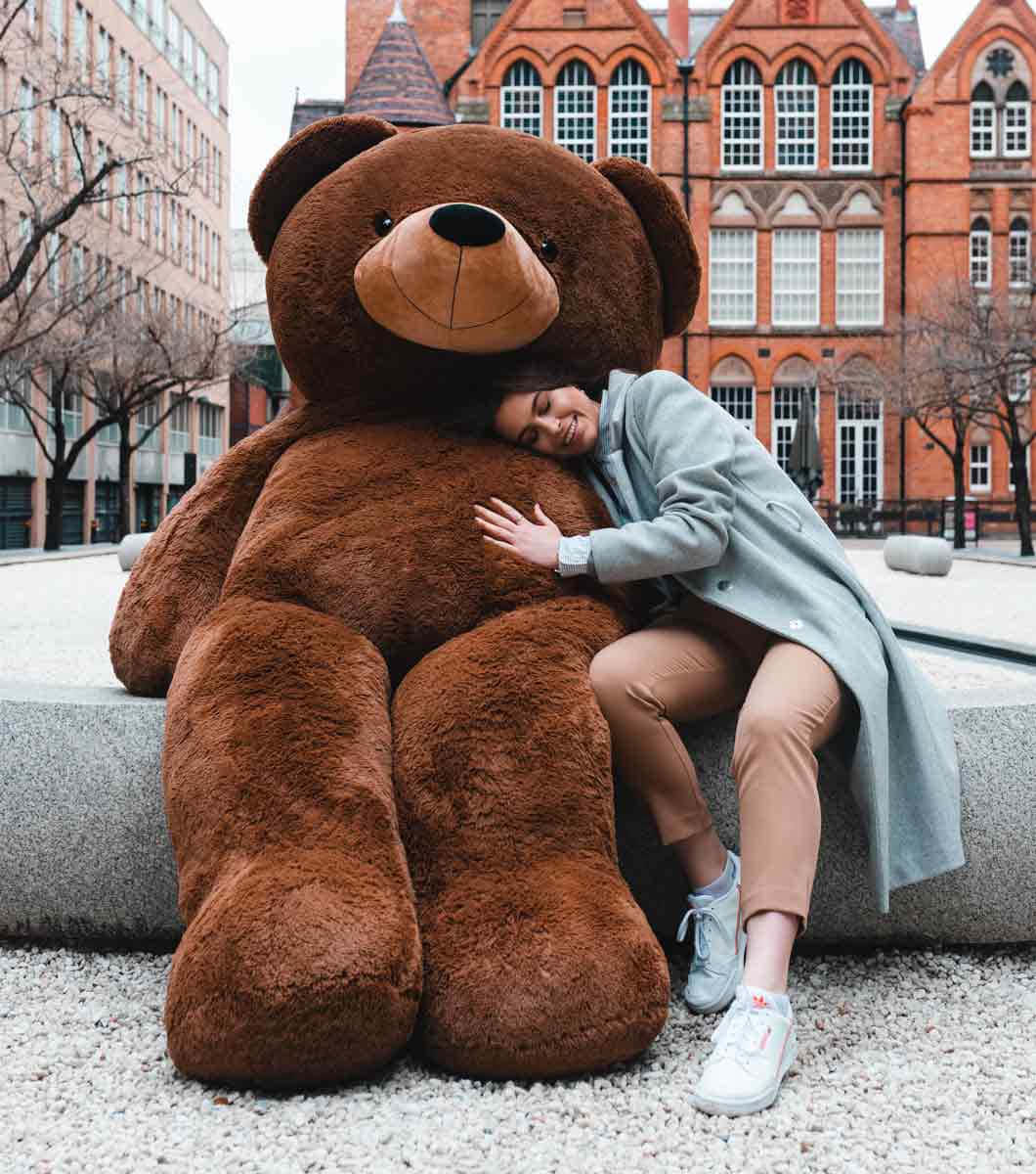 Enbild På En Glad Teddybjörn Som Sitter På En Säng