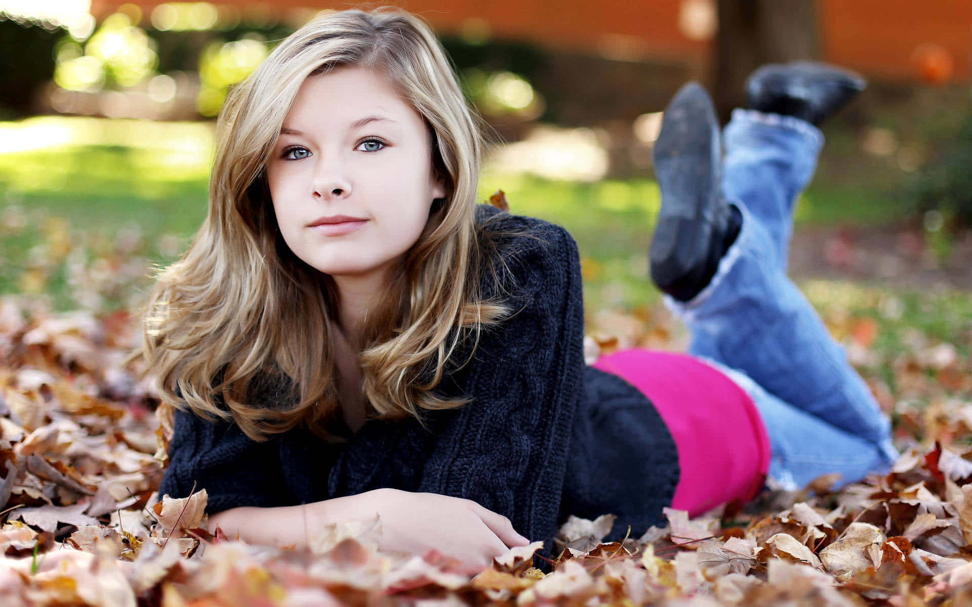 En teenager pige ligge på tørrede blade billede tapet