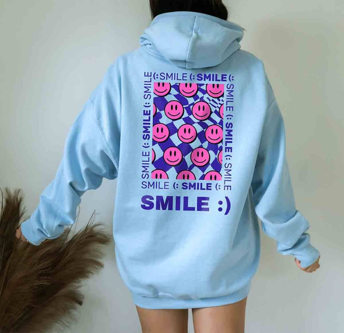 En kvinde iført en blå hoodie med smil på det. Wallpaper