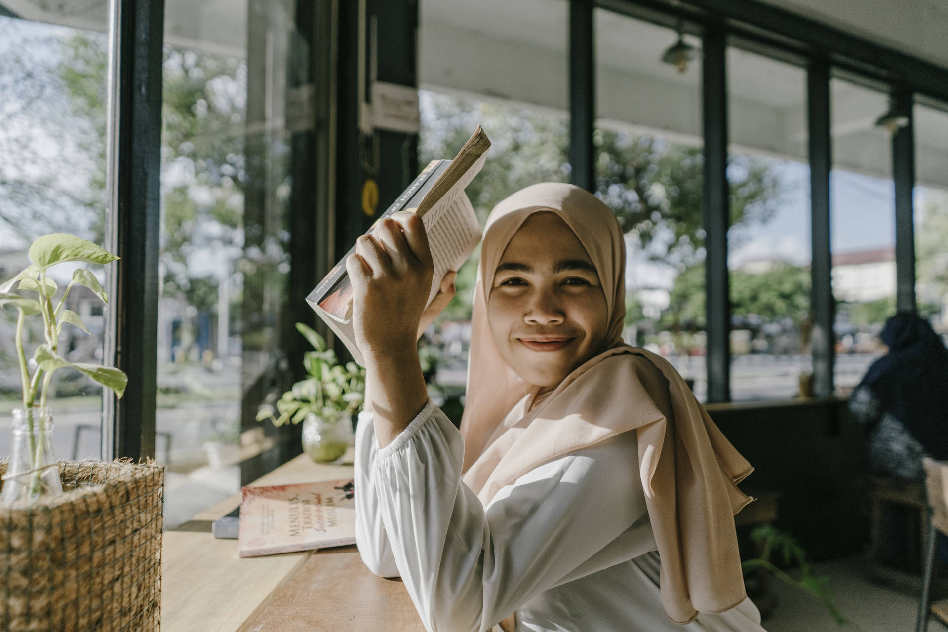 Tonårigmuslimsk Flicka Som Håller En Bok Wallpaper