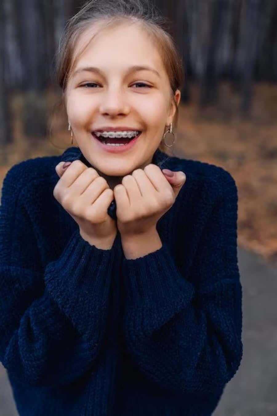 A Girl Smiling With Braces On Her Teeth