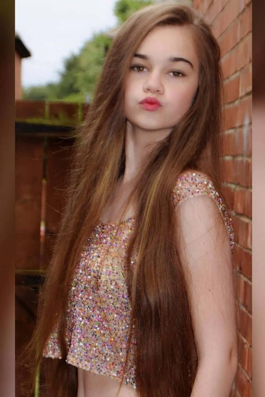 A Young Girl With Long Hair Posing For A Picture