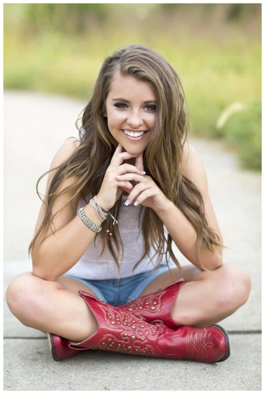 A Girl In Red Cowboy Boots Sitting On The Ground