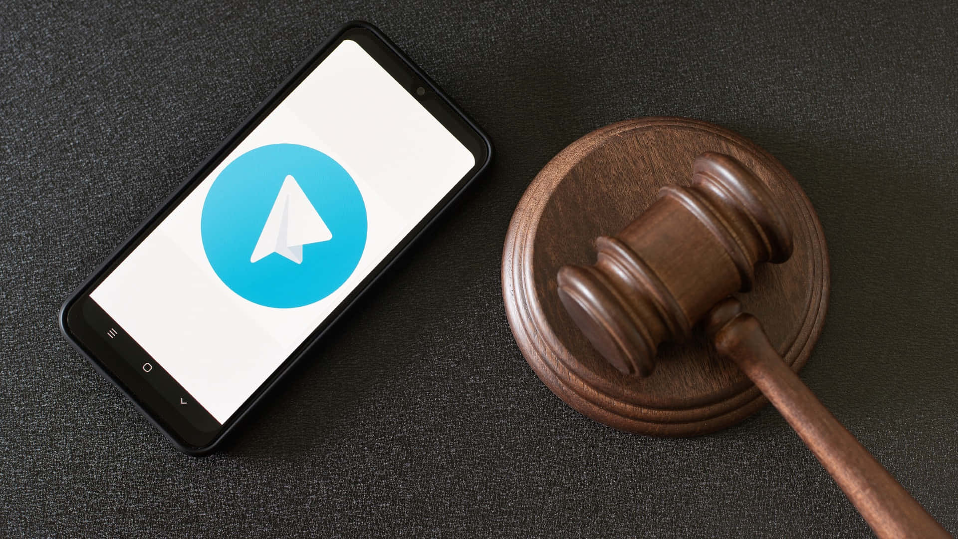A Smartphone With A Gavel Next To It