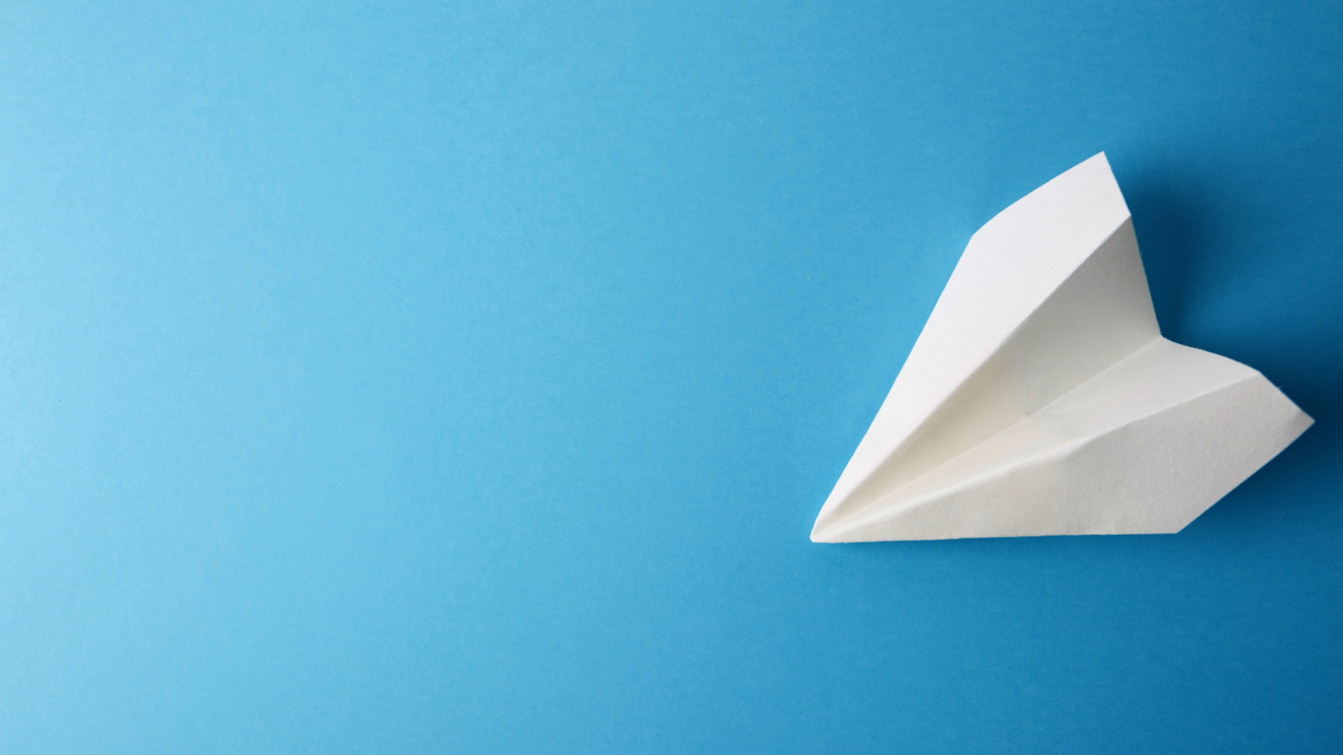 A Paper Airplane On A Blue Background
