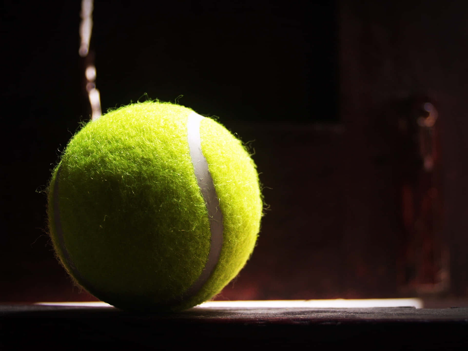 Beskrivelse- Tennisbold, der flyver i slowmotion på et sløret baggrund, der symboliserer et sejrrigt øjeblik. Wallpaper