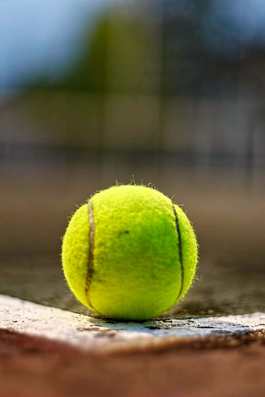 En tennisbold sidder på banen. Wallpaper