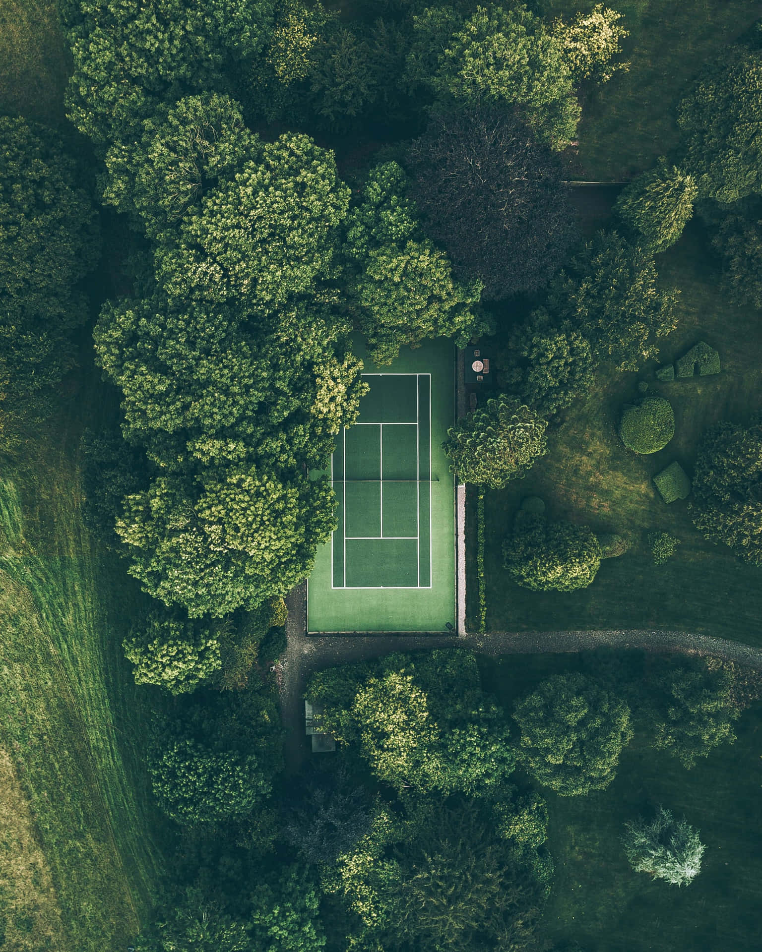 A Tennis Court In The Middle Of A Green Field