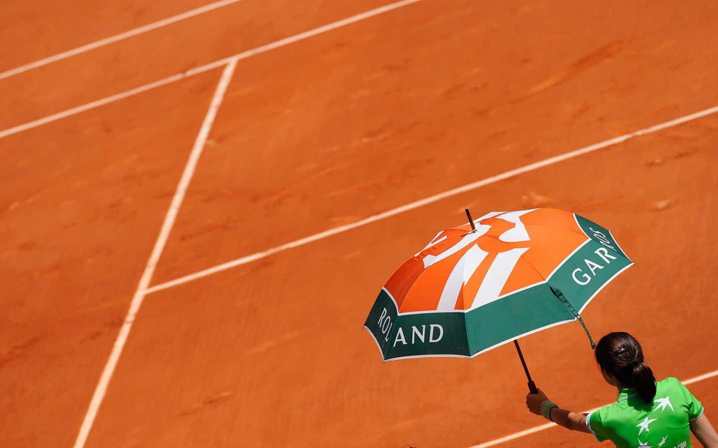 Einefrau Hält Einen Regenschirm Auf Einem Tennisplatz.