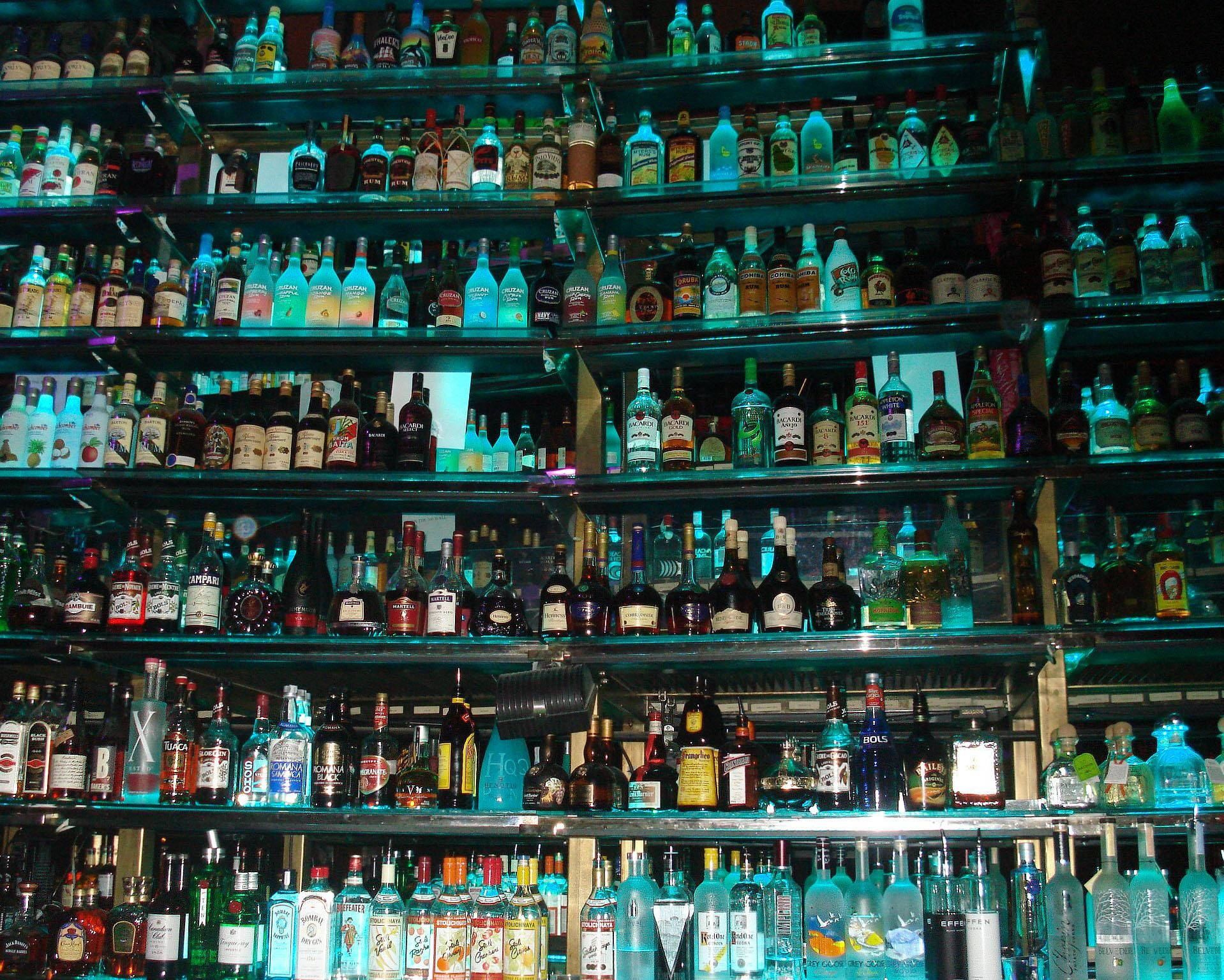 Tequila And Alcohol Bottles On Large Shelf Wallpaper