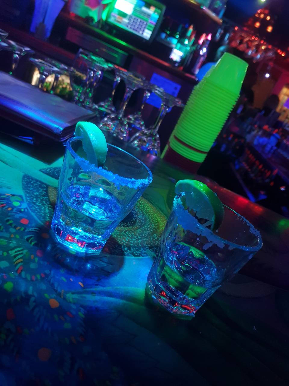 Tequila Shots On Bar Counter With Blue Lights Wallpaper