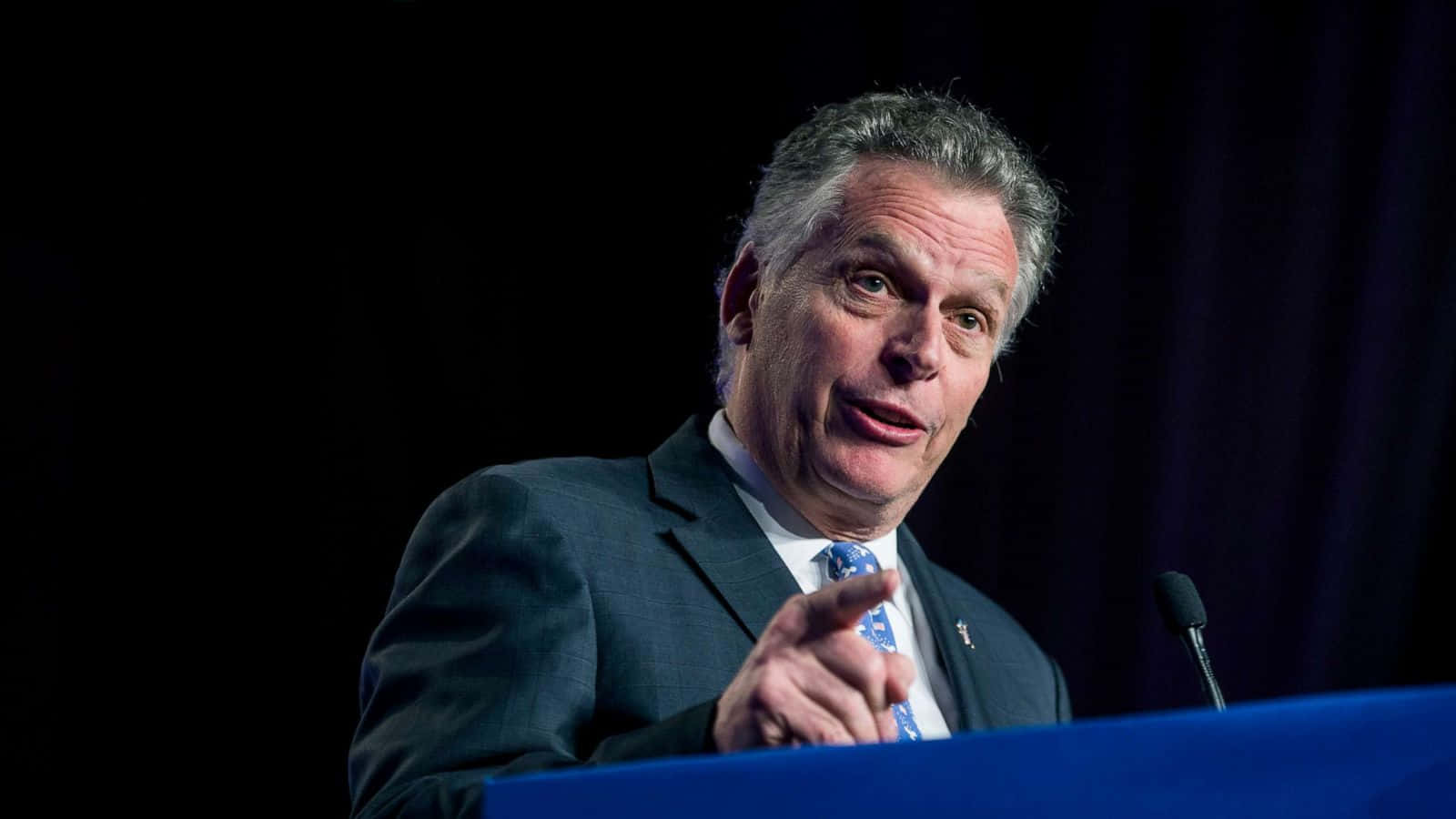 Terry McAuliffe Delivering a Speech at a Podium Wallpaper