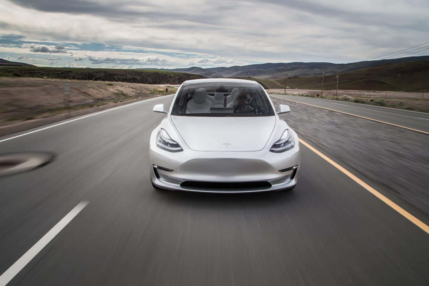 Tesla Model 3 Driving Down A Road
