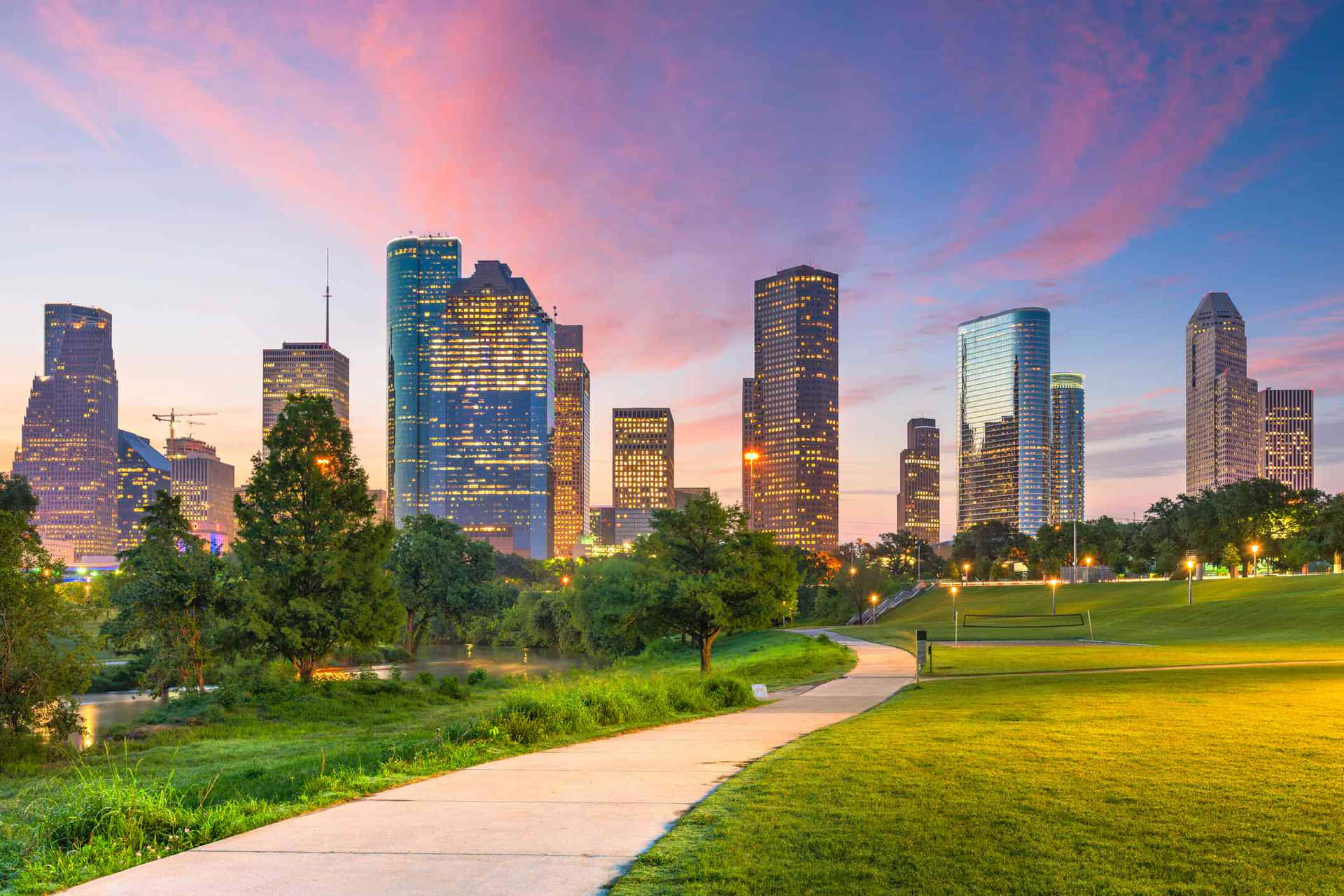 Houston'sskyline Ved Solnedgang Med Park Og Græs.