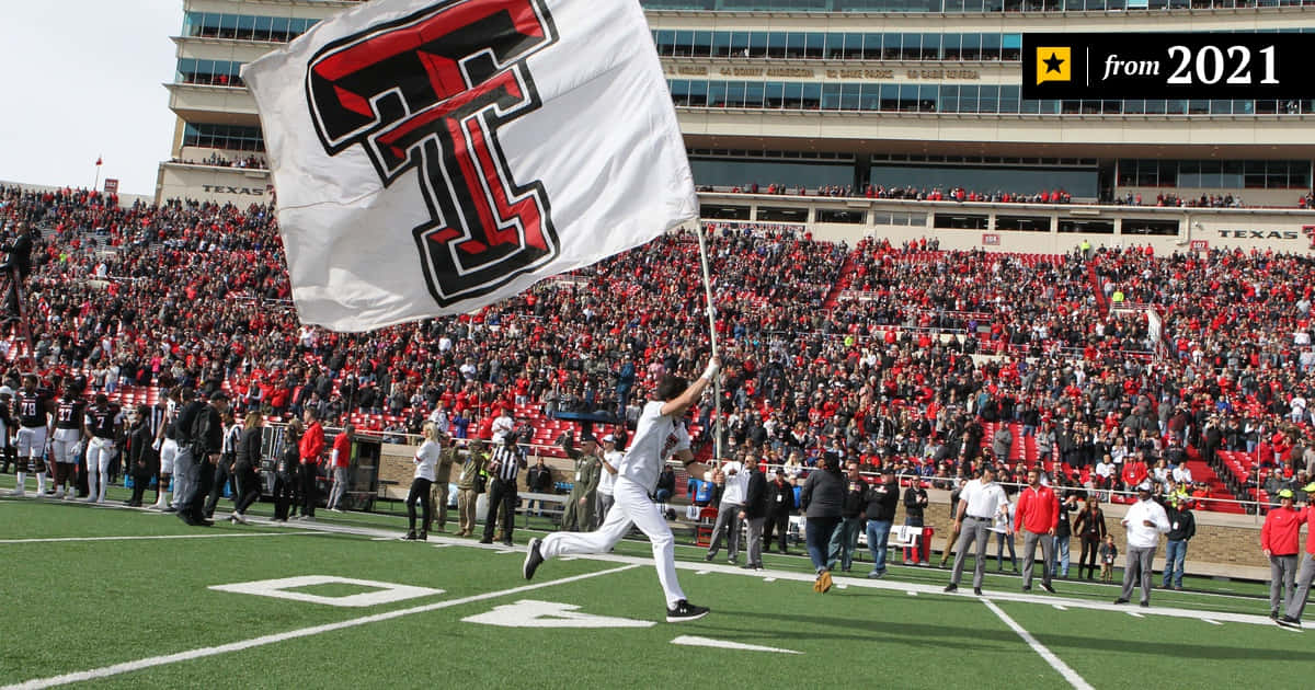 Giocatoredi Football Del Texas Tech Corre Con Una Bandiera Sfondo