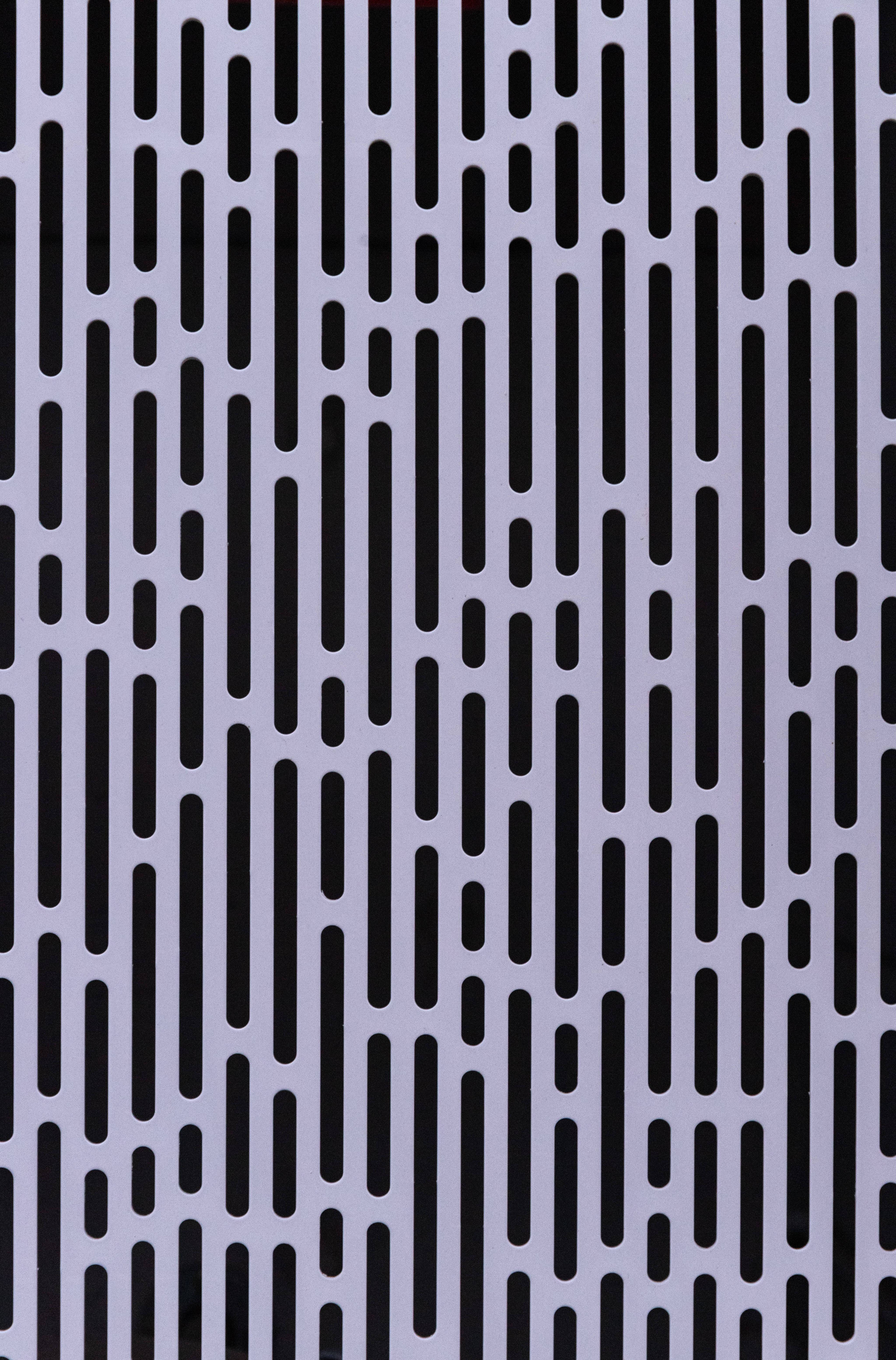 Textured Digital Pattern Wallpaper — A minimalist pattern of black vertical slots on a light gray metallic surface creates a rhythmic geometric texture.
