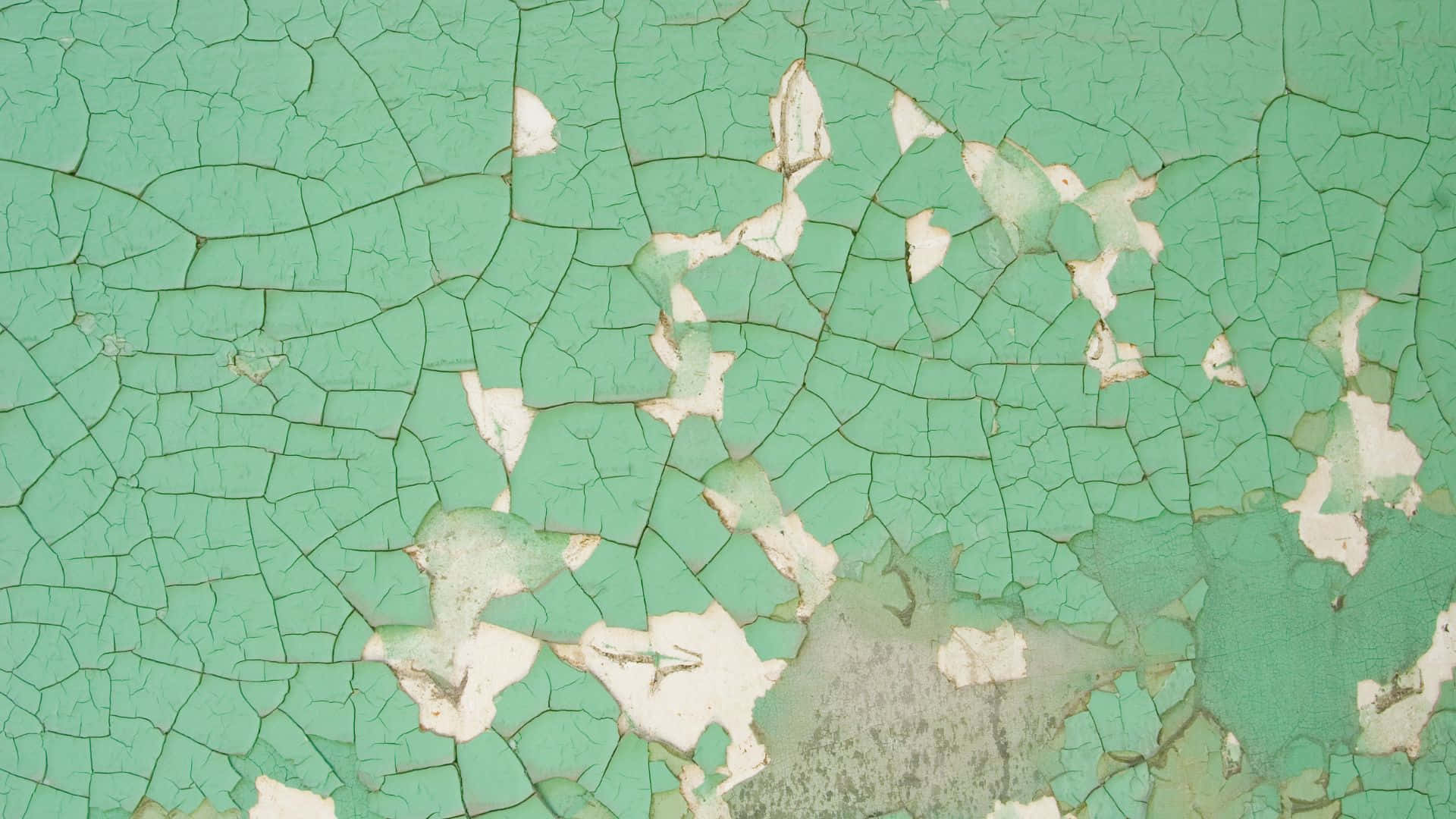 A Green Wall With Cracks And Peeling Paint Wallpaper