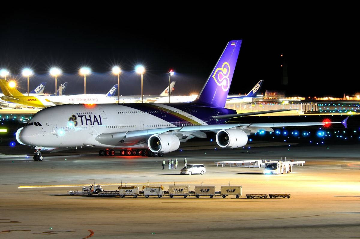 Aviónde Thai Airways Con Autos De Carga. Fondo de pantalla