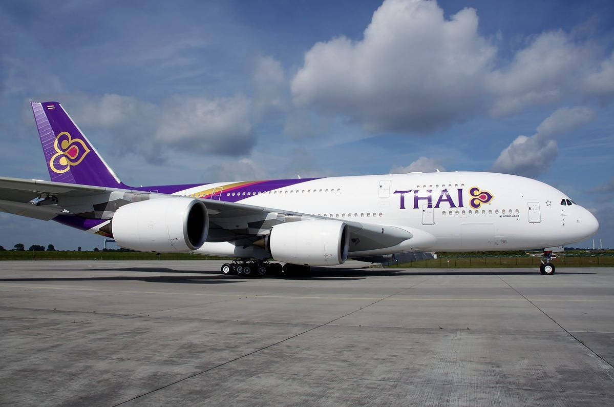 Aviónde Thai Airways Con Cielo Nublado Fondo de pantalla